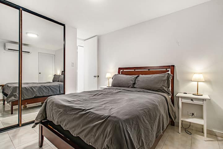 Our second bedroom which includes a full size bed, closet with hangers, A/C unit, two luggage racks, and water views to the Alambique Beach at Isla Verde.