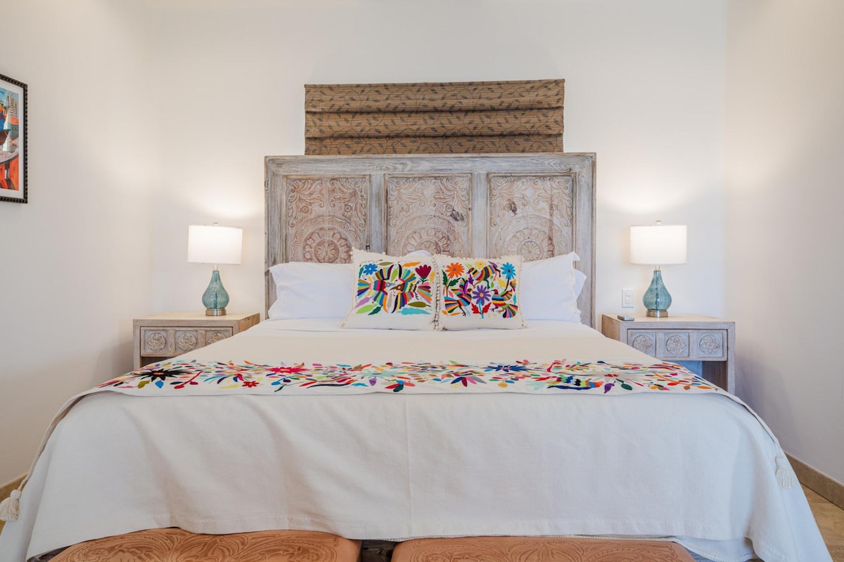 Relájate con estilo con una decoración artesanal y una cama tamaño king enmarcada por una impresionante cabecera tallada. Este dormitorio de la villa ofrece una elegancia tranquila y un refugio acogedor a solo unos pasos de la playa.
