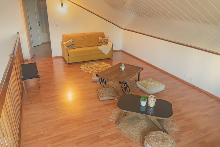 FR : À l’étage, un espace chaleureux avec canapé moelleux, poufs confortables et tables basses pour se détendre

ANG : 
Upstairs, a warm space with a soft sofa, comfortable poufs and low tables for relaxing