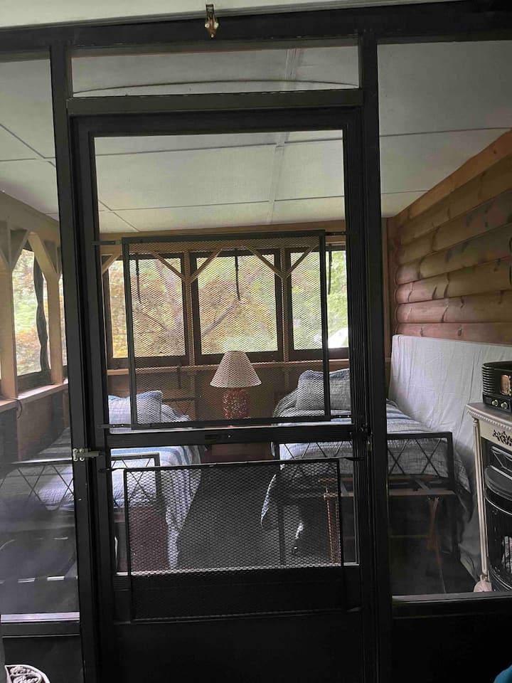 Two Twin beds on outdoor porch on first floor with view of waterfall and portable fan but can get nippy at night. No privacy for dressing and can be used as a daytime napping area in this “guest shared screen porch.”