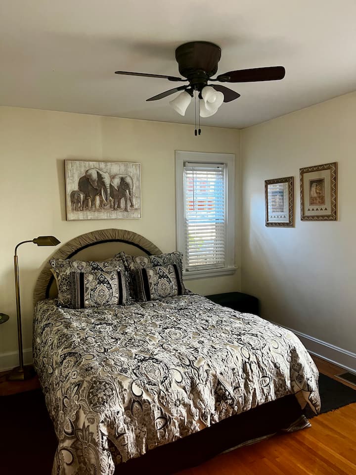 غرفة نوم بحجم كوين في الطابق الأول مع مروحة سقف وإضاءة ليلية وضوء قراءة. مرآة كاملة الطول على باب الخزانة. الحمام مجاور لغرفة النوم.