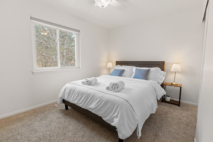 Réveillez-vous à la lumière naturelle et à une vue paisible sur l'arrière-cour depuis cette chambre confortable. Le lit queen size avec matelas en mousse à mémoire de forme a des tables de chevet avec des lampes de chaque côté, et un ventilateur de plafond avec une lumière garde l'espace frais et confortable.