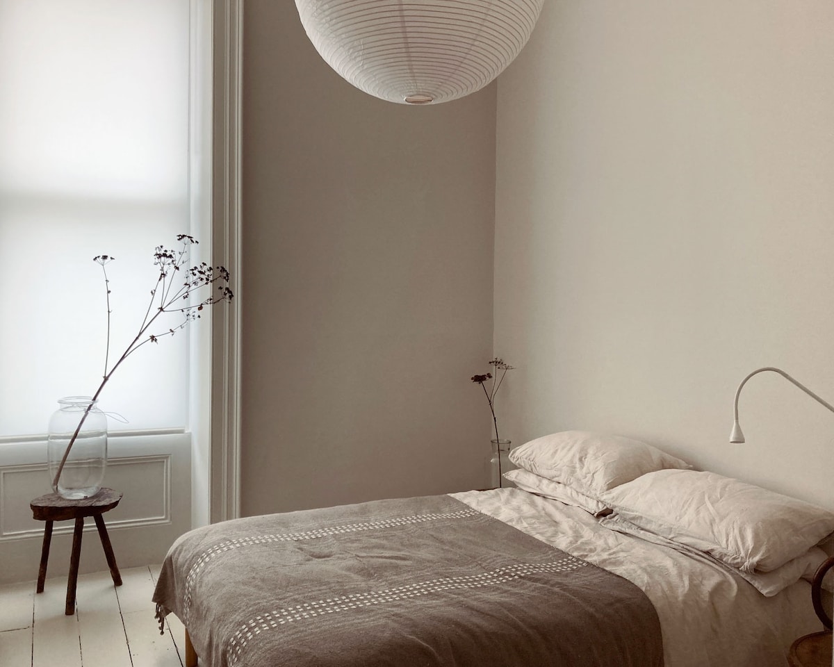 The design of this room is modern, simple, and calming, in keeping with the rest of the apartment. The tall window with street views and high ceilings add to the airy, relaxing space. 