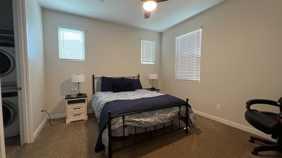 Bright master bedroom with queen bed, nightstands, and ample natural light—designed for comfort and relaxation.