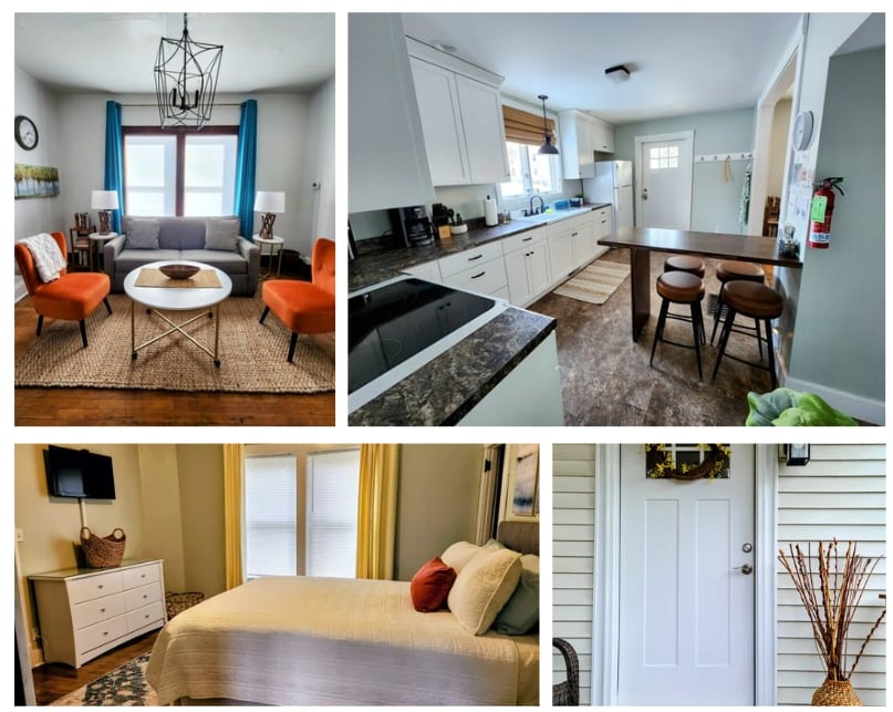 A cozy living area features a grey sofa flanked by two orange accent chairs, with a round coffee table at its center. Light enters through large windows, complemented by colorful curtains, creating a welcoming space for relaxation.