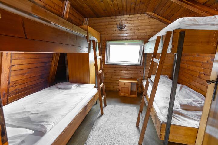 غرفة نوم كبيرة بسريرين بطابقين.