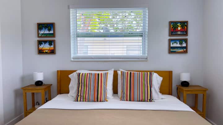 End long beach days between crisp sheets on the king bed, with a reading lamp on each side and beach art overhead. Couples tell us they sleep better here than they ever expected to on vacation.