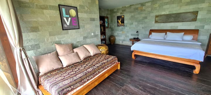 Extra bed/day bed by window on left, with center, King sized bed