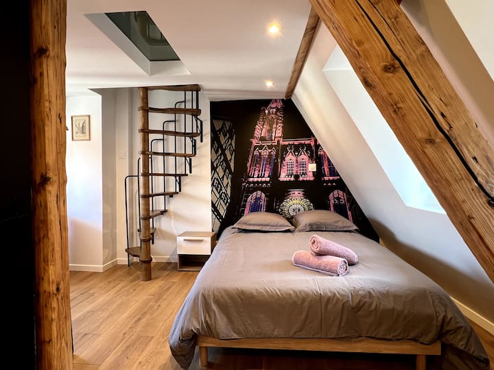 Dhomë gjumi me trarë origjinalë të ekspozuar.