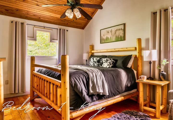 Drift off to sleep in this charming bedroom featuring a log bedframe, cozy linens, and warm wood tones.