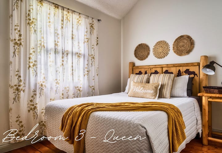 Drift off to sleep in this bright and airy queen bedroom, surrounded by natural light and cozy cabin vibes.