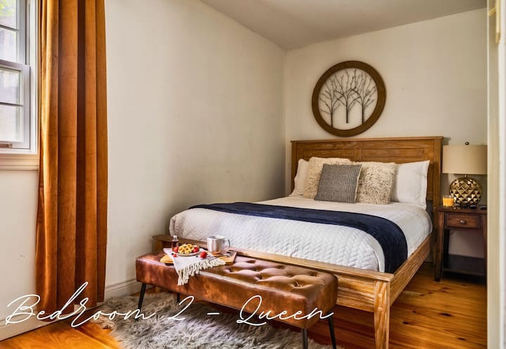 Sleep soundly in this bright and airy bedroom with soft linens, rustic decor, and plenty of natural light to start your day refreshed.