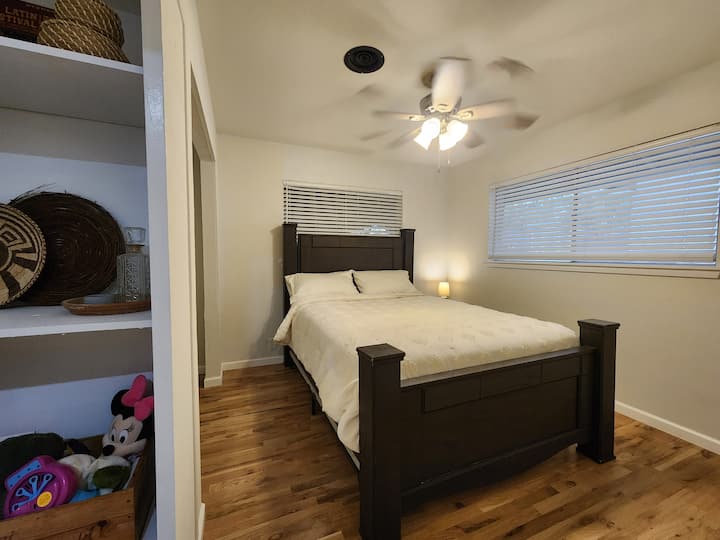Dormitorio trasero con cama de tamaño completo y armario abierto. Ropa de cama lavada o reemplazada entre todos los huéspedes.