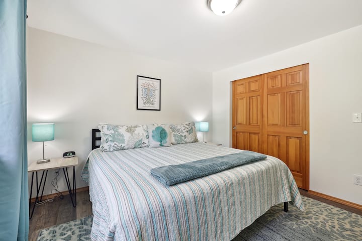 Twin nightstands frame the king size bed, each with its own USB charging port. The full size closet has durable hangers, a luggage rack, and a laundry basket.