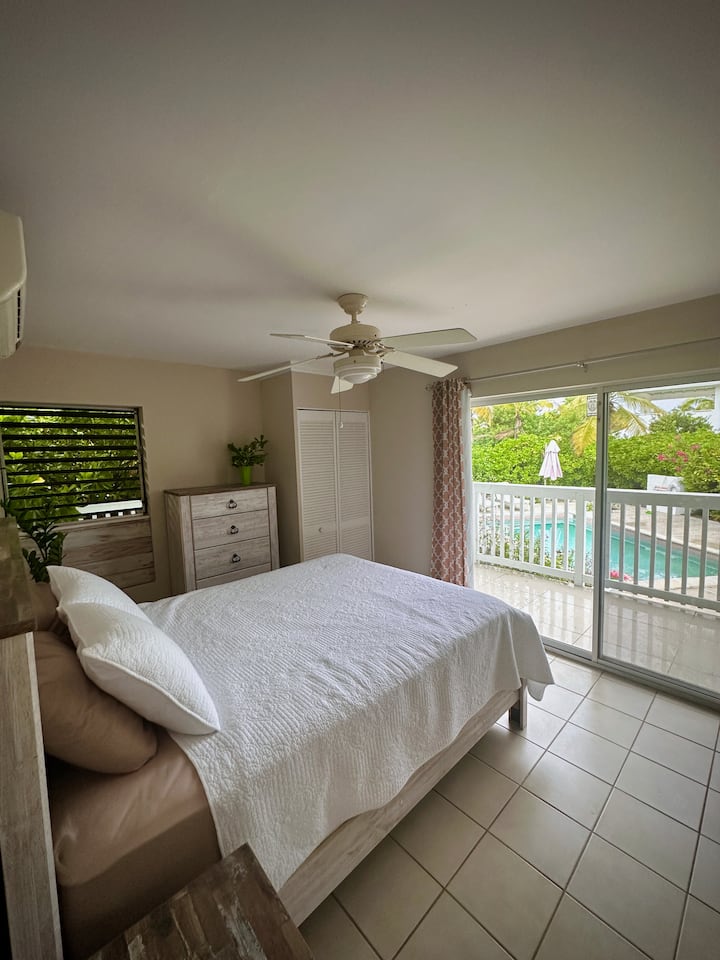 Dormitorio de la planta principal junto a la piscina con su propio baño completo, acceso al patio y a la piscina.