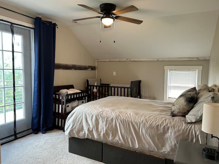 Dormitorio principal: cama tamaño queen, lámparas de noche con cargadores USB y soportes para teléfonos, cuna de tamaño completo y estación de cambio