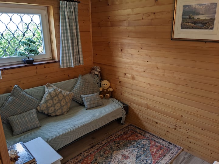 Dhomë e lirë jashtë dhomës kryesore të gjumit me divan krevat dhe hapësirë për krevat fëmijësh