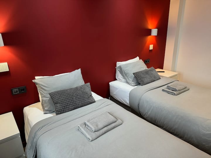 Ორი ერთადგილიანი საწოლი პირველ საძინებელში. Საწოლის სანათები და მოწყობილობების დასამუხტი ადგილი საწოლის გვერდით.