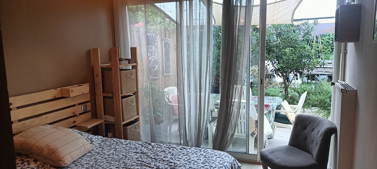 спална соба со поглед на тераса со маса  и градина 