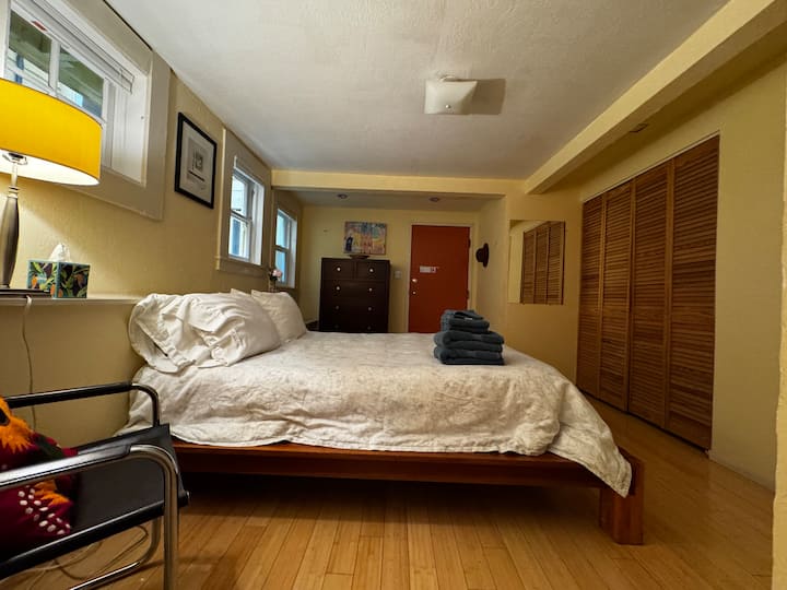 Bedroom w/ wood floors, simple furnishings & a calm atmosphere.
