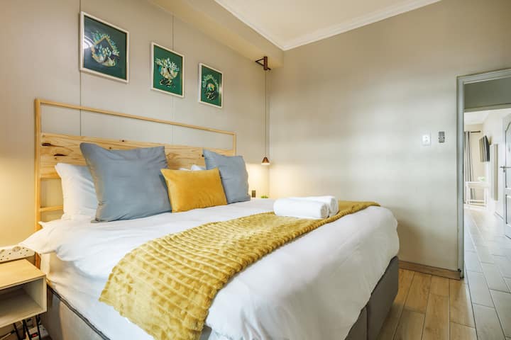 温馨迷人的卧室，配有植物艺术品、多层纺织品和柔和的中性色调，专为舒适休息而设计。