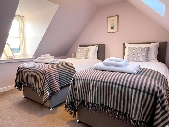 שתי מיטות יחיד למעלה. עיצוב נקי וקלאסי. מצעי כותנה מצריים ומגבות לבנות נקיות. נוף לדרום ולצפון.