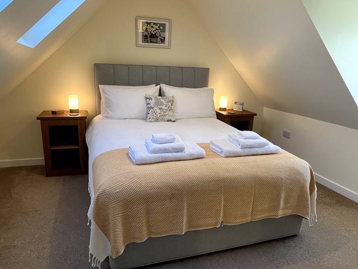 מיטת קינג סייז למעלה. היכנסו לארון בגדים עם שטח אחסון, שידות ליד המיטה עם אורות צד ושעון מעורר.