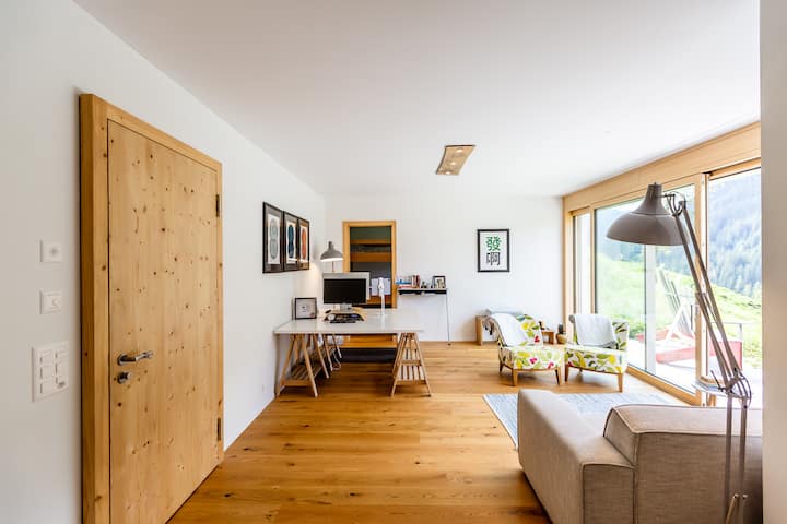 Salon spacieux et élégant avec éclairage doux, idéal pour se détendre après une journée à la montagne.