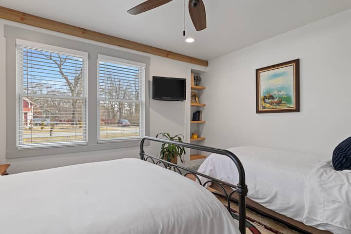 ห้องนอนด้านหน้าชั้นหลักพร้อมเตียงควีนไซส์และเตียงเดี่ยว