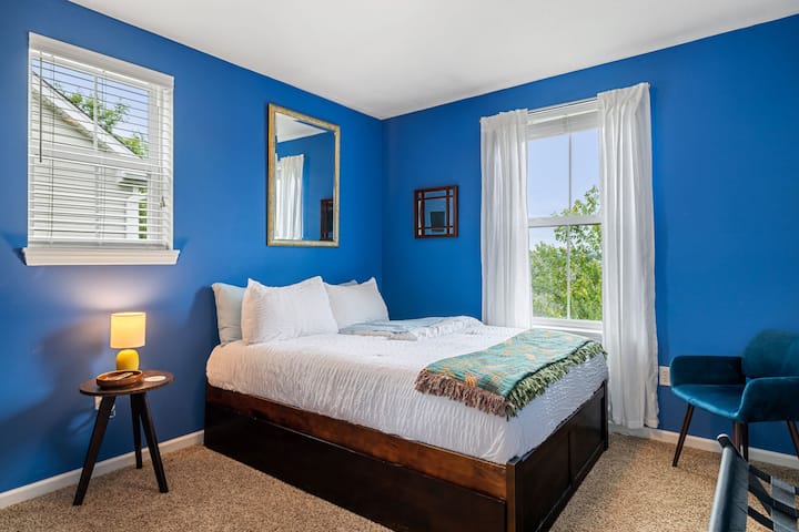 جدران جريئة، راحة هادئة – تمزج غرفة النوم الثانية هذه الألوان العميقة مع الأبيض الساطع والقوام المريح لمحيط مريح ونابض بالحياة.