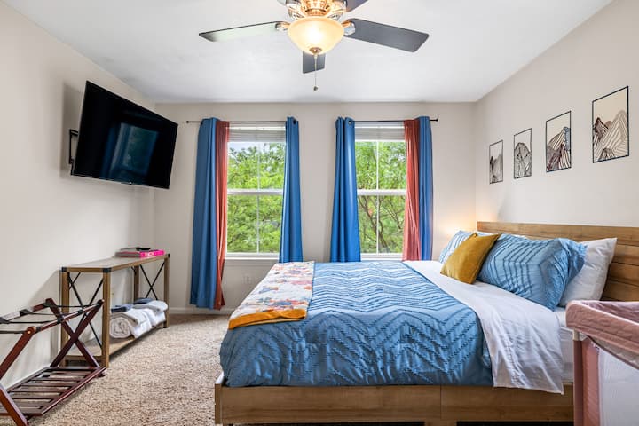 ضوء الشمس والمساحة الواسعة والألوان الزرقاء الهادئة – تدعوك غرفة النوم الرئيسية للاسترخاء والاستمتاع بإطلالات على قمم الأشجار خلف النوافذ.