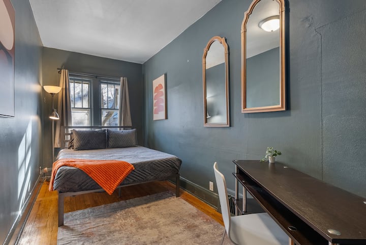 Chumba hiki cha kulala cha ghorofa ya kwanza kinachovutia kinatoa mwanga mwingi wa asili kupitia madirisha makubwa, na kuunda mwonekano angavu na wenye hewa safi. Vioo huongeza nafasi, wakati sehemu ndogo mahususi ya kufanyia kazi inatoa eneo rahisi kwa ajili ya kazi au masomo. 