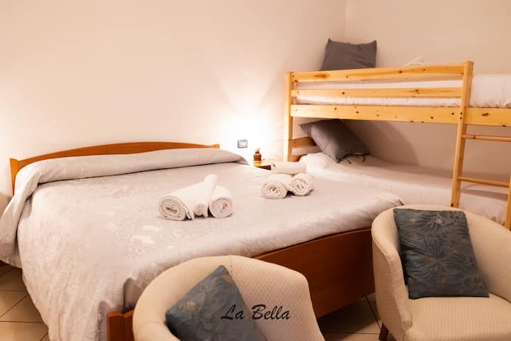 This room offers a spacious and comfortable environment, ideal for families or groups of friends. The room is furnished with a double bed, a bunk bed and two sofas, offering different solutions for rest.