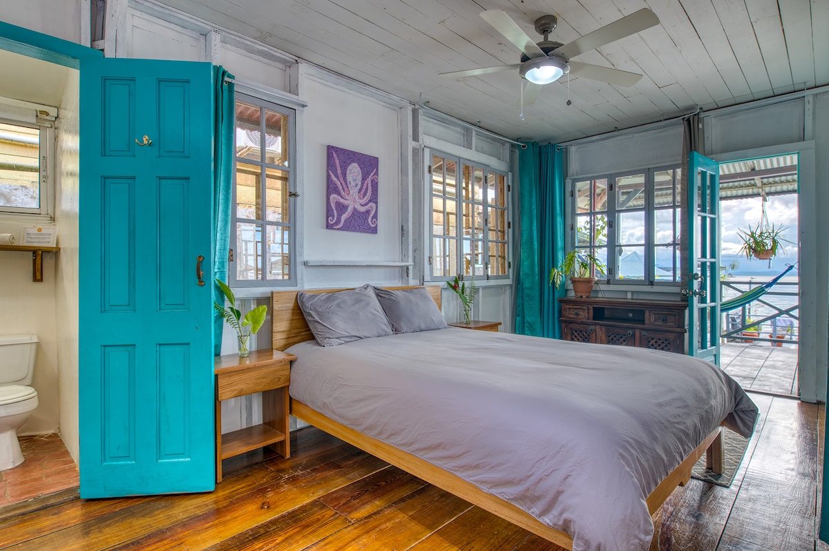 Habitación frente al mar con cama tamaño queen, vestidor y baño privado adjunto.