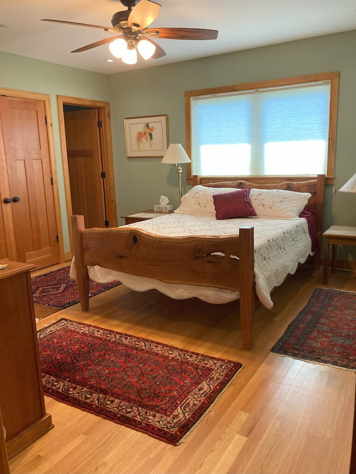 Amplia suite tamaño queen amueblada con cereza hecha a mano, ubicada convenientemente en el primer piso, baño privado, armario generoso y ventilador de techo.