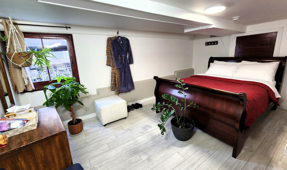 Chumba cha pili cha kulala cha ghorofa ya chini ambacho kinaangalia nje juu ya ua mkubwa, bustani na gazebo.