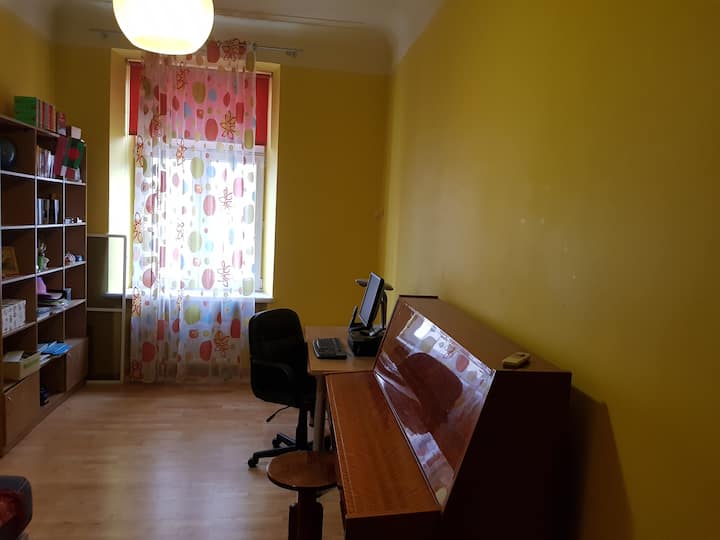 Piano, gabinete grande y escritorio con silla.