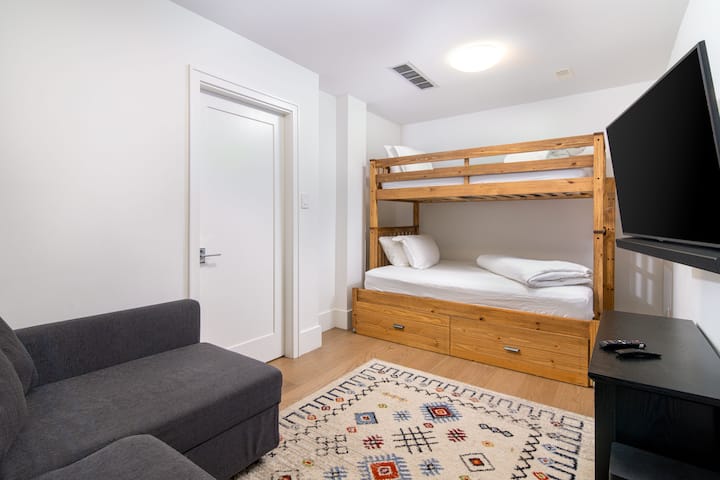 The lower level features a fun and functional bunk bed with a double on the bottom and twin on top, perfect for kids or extra guests. Plus, a pull-out sofa bed with bedding stored inside provides additional sleeping space for comfort and convenience.