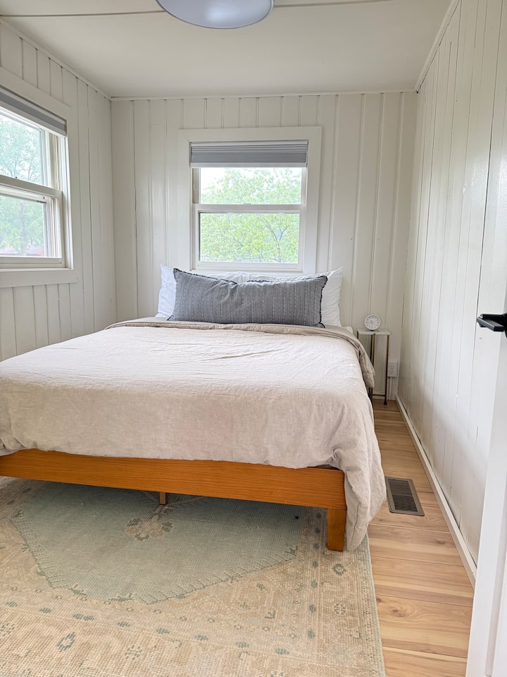 Kitanda cha ukubwa wa malkia kilicho na godoro na mashuka ya pamba ya asili.