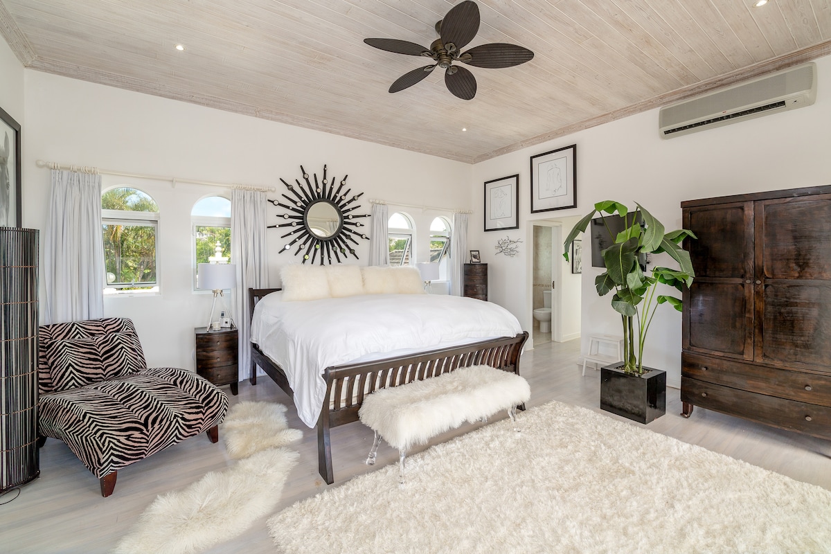 Էլեգանտ գլխավոր ննջասենյակ ՝ ԱՄՆ - ում մեծ մահճակալով, պարտեզի և ծովի տեսարաններով, առանձին տեռասով, սմարթ հեռուստացույցով և առանձնաբաժնով ։