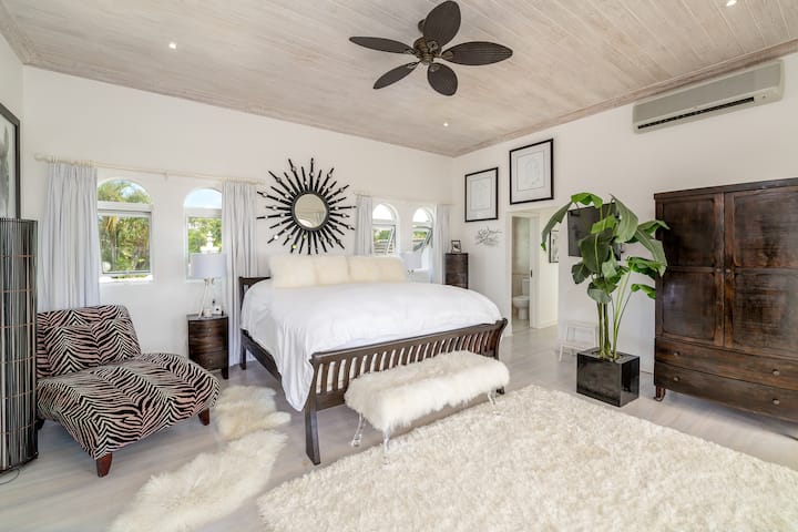 Էլեգանտ գլխավոր ննջասենյակ ՝ ԱՄՆ - ում մեծ մահճակալով, պարտեզի և ծովի տեսարաններով, առանձին տեռասով, սմարթ հեռուստացույցով և առանձնաբաժնով ։