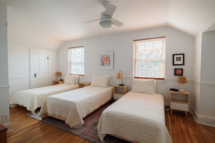 The 4th bedroom is upstairs and has three or four twin beds. It also has a Smart TV. Each bed has a reading light and a bedside table.  The closet for this room is to the right. The closet that we can see is a small eve closet and it is locked. 