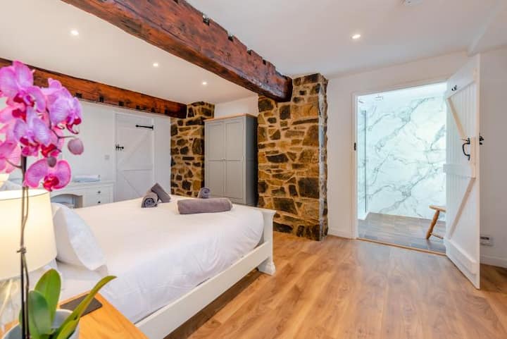 Dormitorio 5 con cama tamaño king en la planta baja con ducha a ras de suelo.