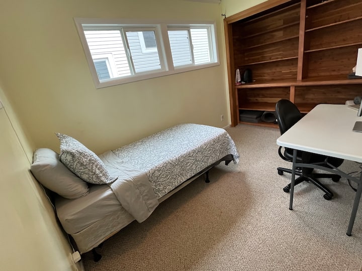 Chambre avec lits jumeaux et bureau au rez-de-chaussée
