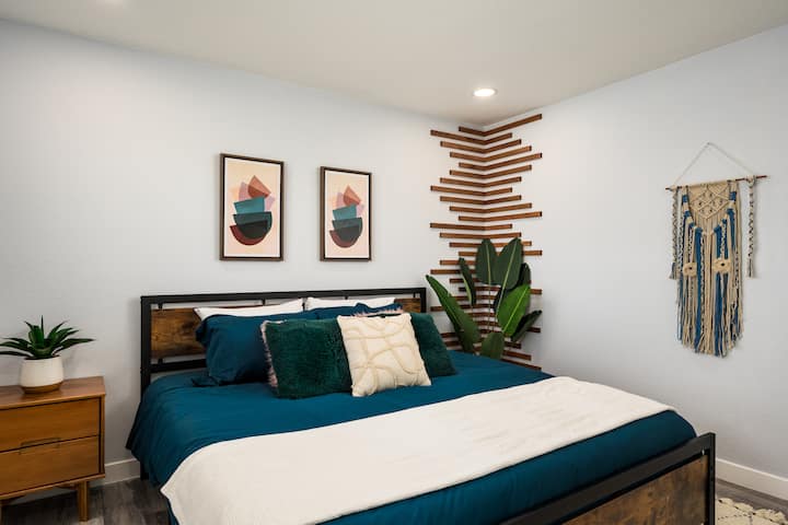 בחדר השינה השני יש מיטה זוגית גדולה, טקסטיל בשכבות ופרטי קיר ייחודיים שמעניקים לנכס גם נוחות וגם אופי.