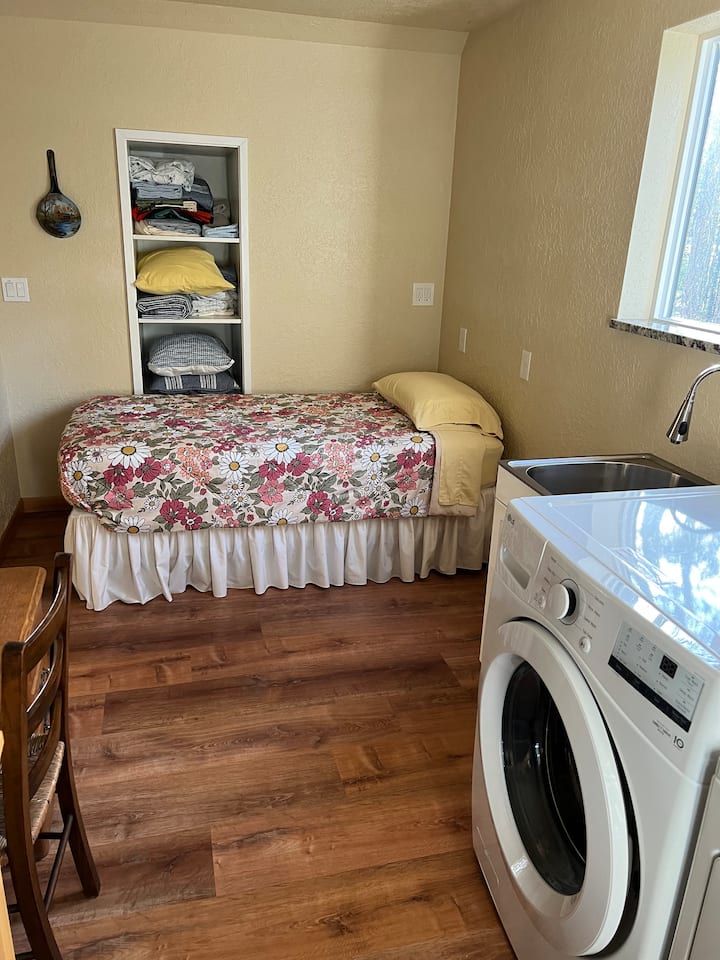 Esta habitación multiusos incluye una cama doble, lavadora y secadora, un horno tostador de encimera y ventilador de habitación.