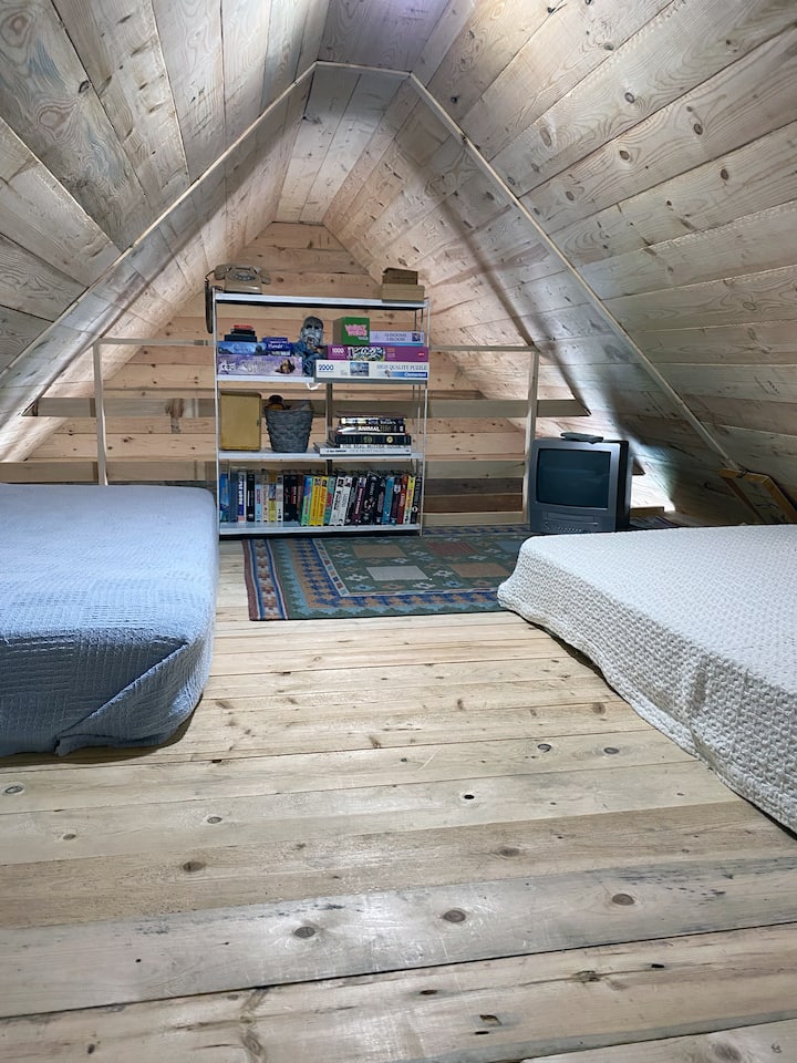Een kleine loftruimte met twee eenpersoonsbedden, plus VHS-speler, tapes, spelletjes en speelgoed. Deze ruimte bevindt zich boven de keuken, met een open uiteinde en een kleine deur van het tweede kantoor/yogaruimte. (De deur naar deze kamer is erg klein - een volwassene moet hurken of kruipen.)