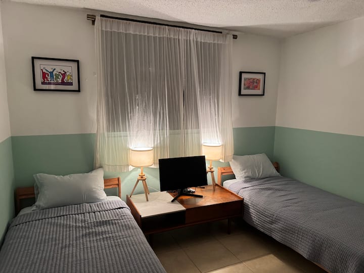 توفر هذه الغرفة سريرين مفردين يمكن ترتيبهما معًا للحصول على خيار نوم متعدد الاستخدامات.