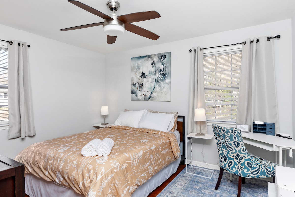 Ova spavaća soba ima prostor za rad, neutralne boje s mirnim umjetničkim djelima i plišanu, udobnu posteljinu. 