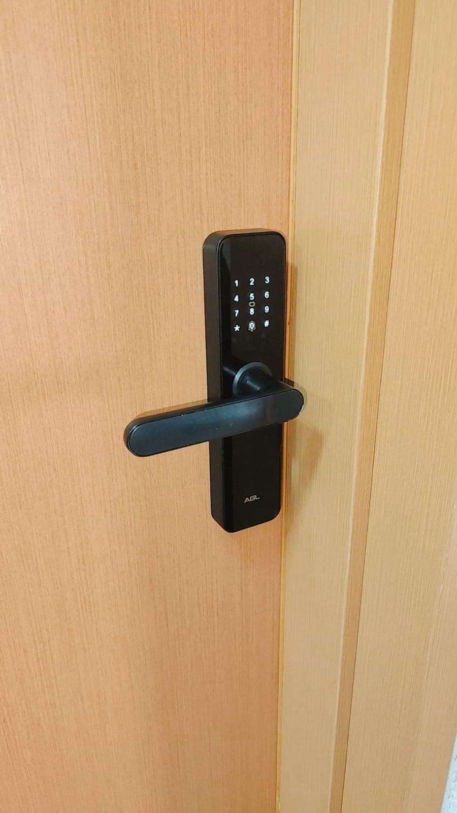 A modern electronic door lock is attached to a wooden entry door. The sleek design features a keypad for access, ensuring security and convenience for guests.